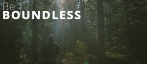 A person in a hooded jacket stands in a sunlit forest. Large text in the top left reads "Be Boundless." Explore new horizons with our Admissions program.