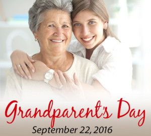 An elderly woman and a young woman smile at the camera while embracing, with the text "Grandparent's Day" written in red at the bottom of the image.