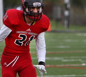 A football player wearing a red Kentucky Christian jersey with the number 21 and a helmet, on a field.