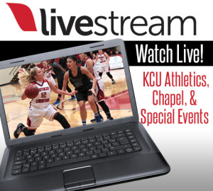 A laptop screen displays a livestream of a basketball game. The text reads, "Watch Live! KCU Athletics, Chapel, & Special Events.
