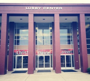 Entrance of a building with three glass doors, each labeled with the words "Christ," "Character," and "Career" in red signs above.