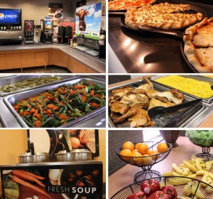 A buffet spread featuring trays of green beans, mixed vegetables, roasted chicken, corn, and a basket of oranges.