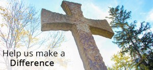 Stone cross under a blue sky with trees in the background and the text "Help us make a Difference" in the lower left corner.