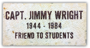 Plaque reading, "Capt. Jimmy Wright 1944-1984 Friend to Students" in black text on a textured white background.
